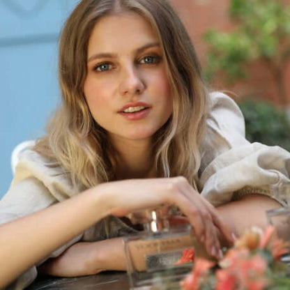 Mujer relajada con fragancia Linet Eau de Parfum, destacando estilo y elegancia en un ambiente natural.